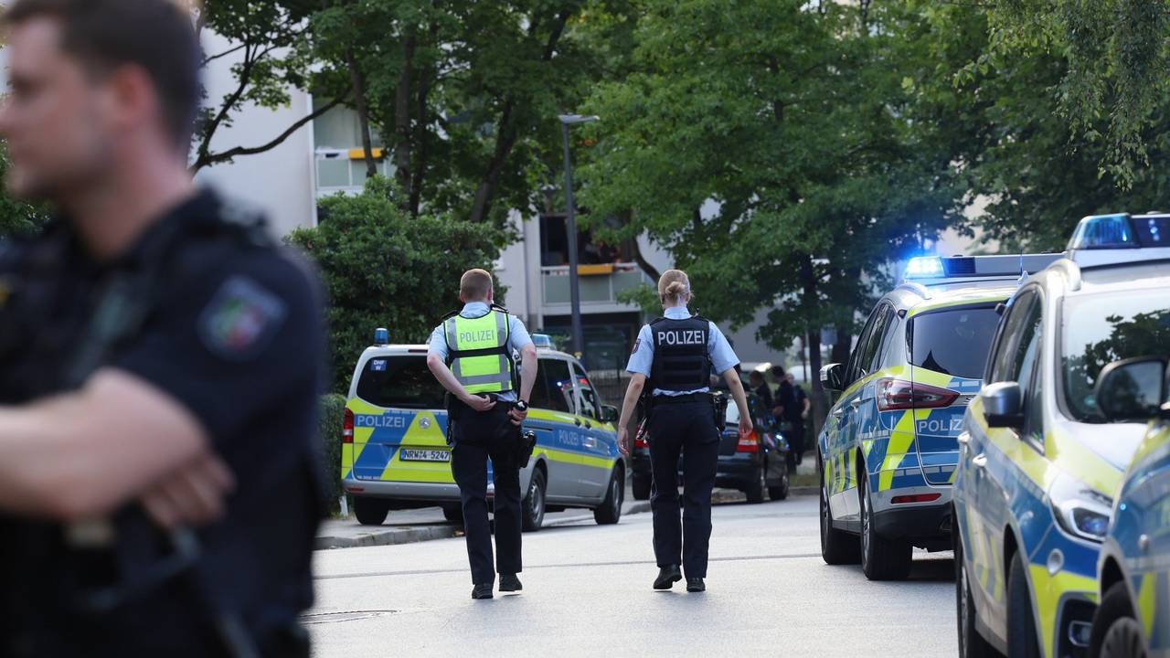 Streifenwagen der Polizei stehen in einem Wohngebiet auf der Straße.