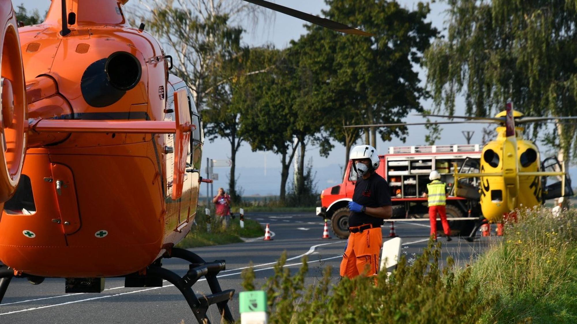 Einsatzkräfte stehen neben einem Rettungshubschrauber auf einer Landstraße (Symbolfoto).