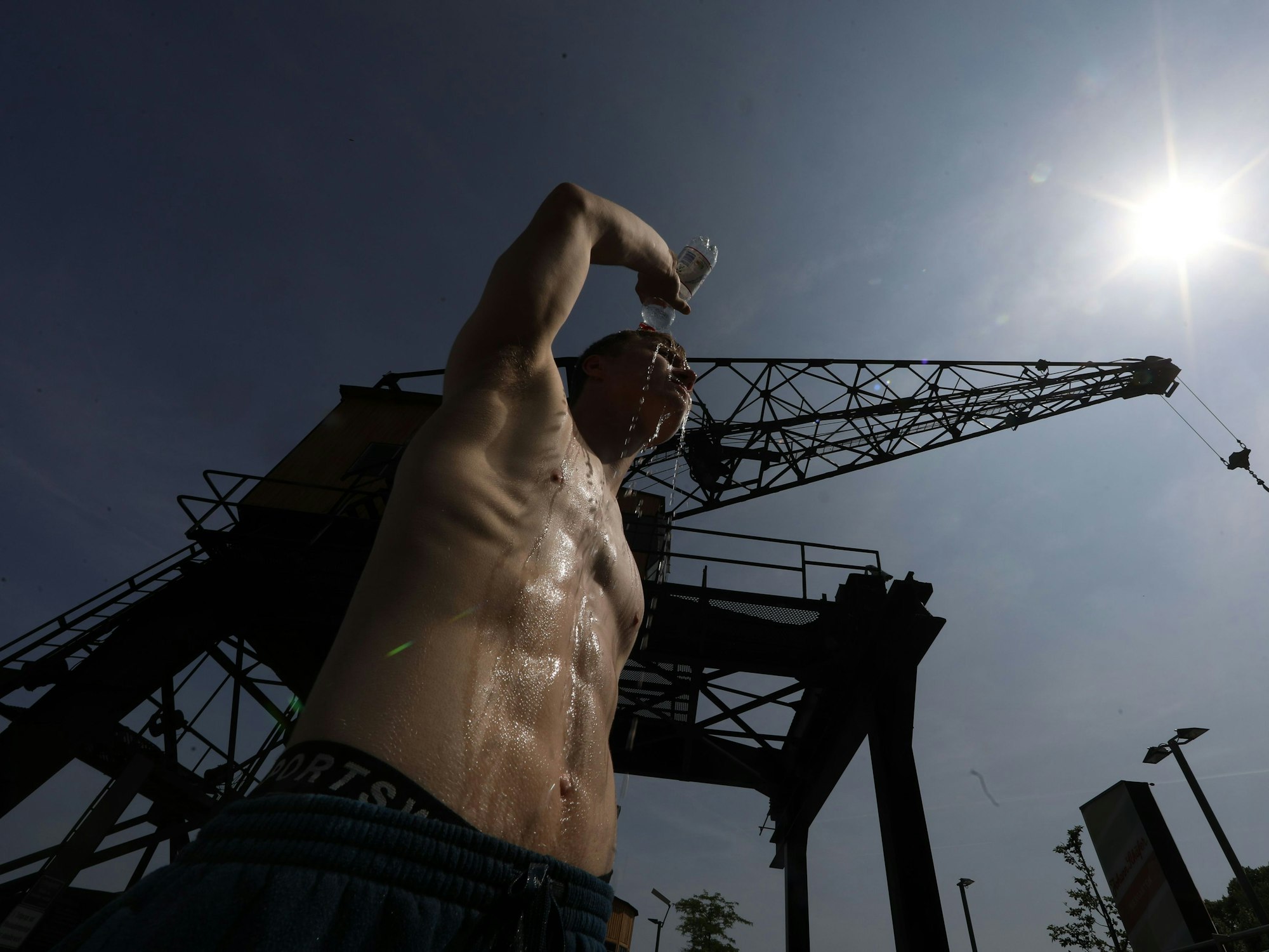 Ein Mann schüttet Wasser über seinen Körper.