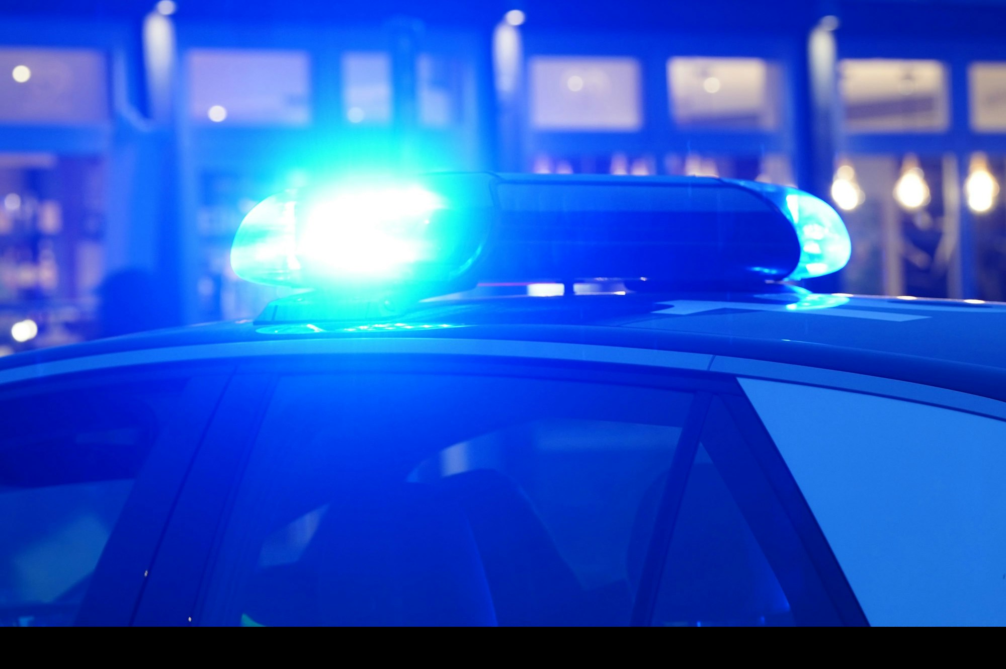 Ein Streifenwagen der Polizei steht auf einer Straße.