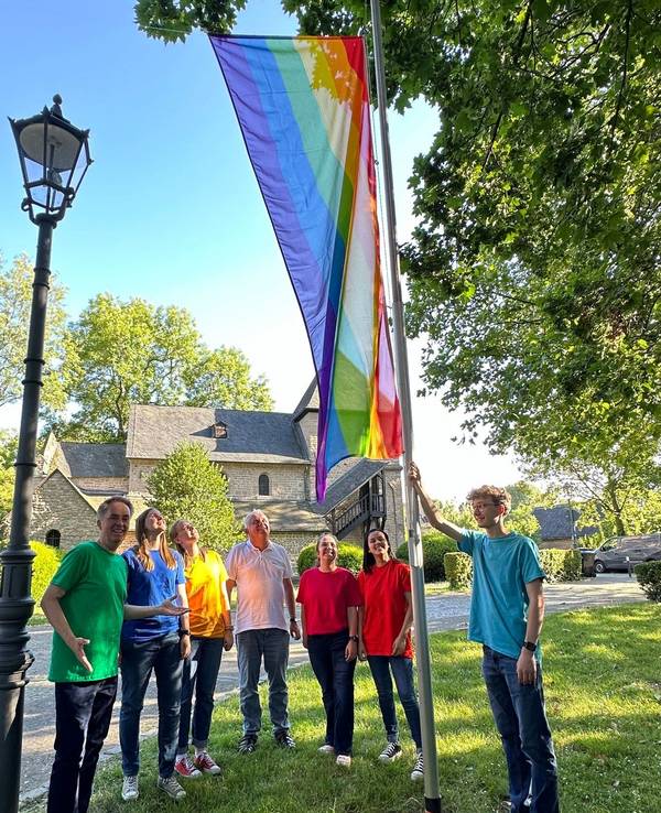 Der Jugendchor hisst die Regenbogenflagge an der Kirche.