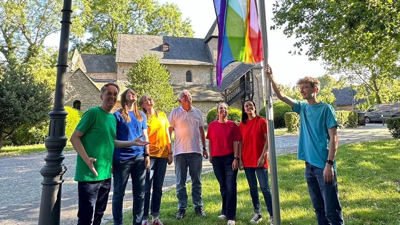Der Jugendchor hisst die Regenbogenflagge an der Kirche.