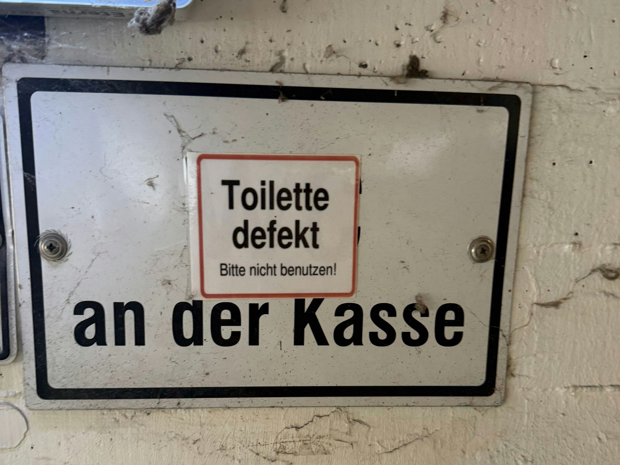 Ein Schild mit der Aufschrift: Toilette defekt.
