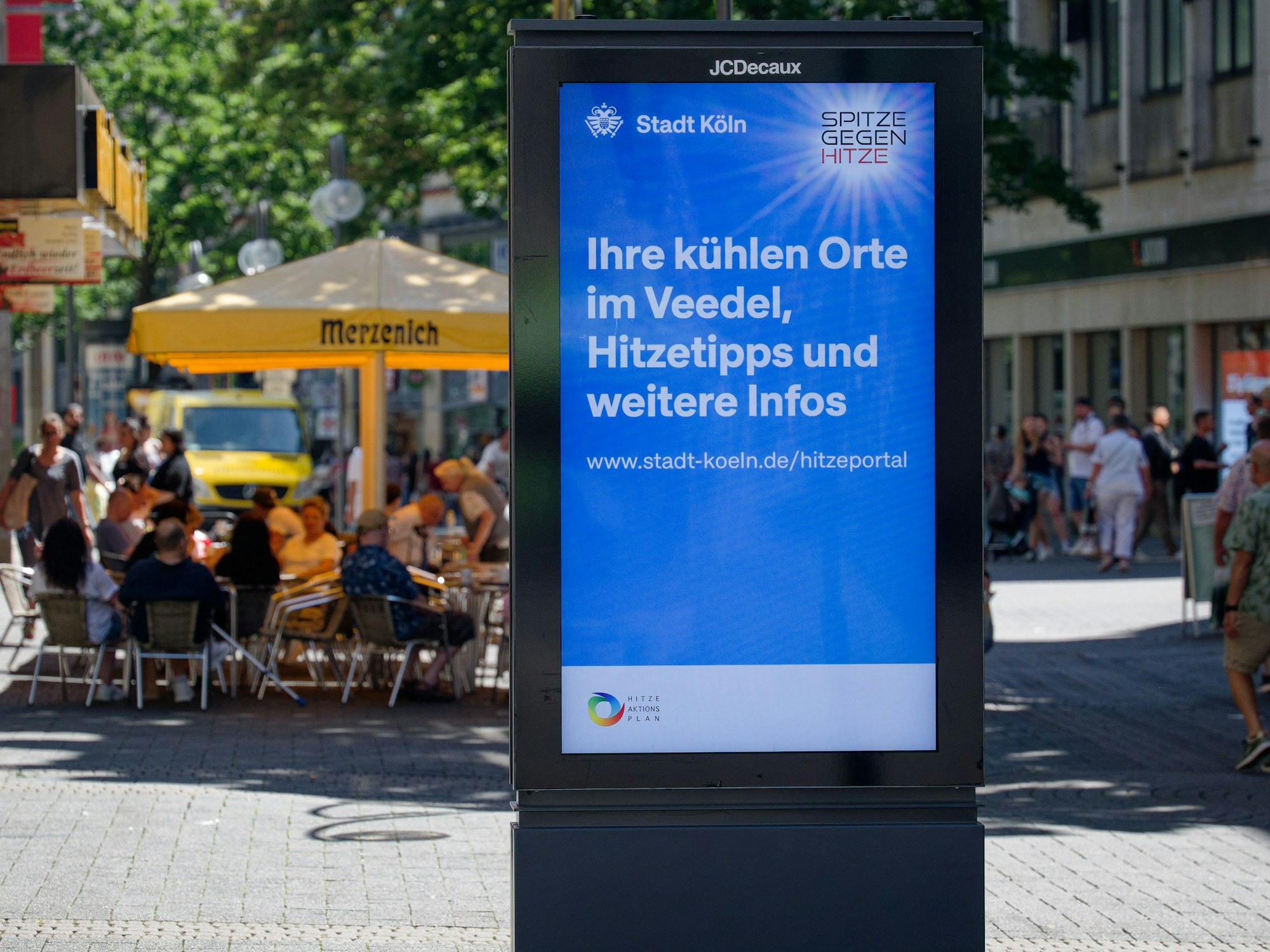 Die Stadt Köln wirbt auf einem Standmonitor für das Hitzeportal mit Tipps bei heißem Wetter.