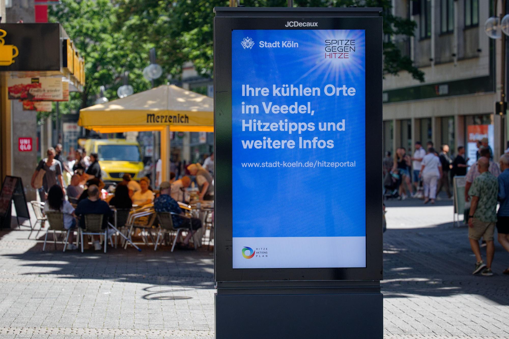 Die Stadt Köln wirbt auf einem Standmonitor für das Hitzeportal mit Tipps bei heißem Wetter.