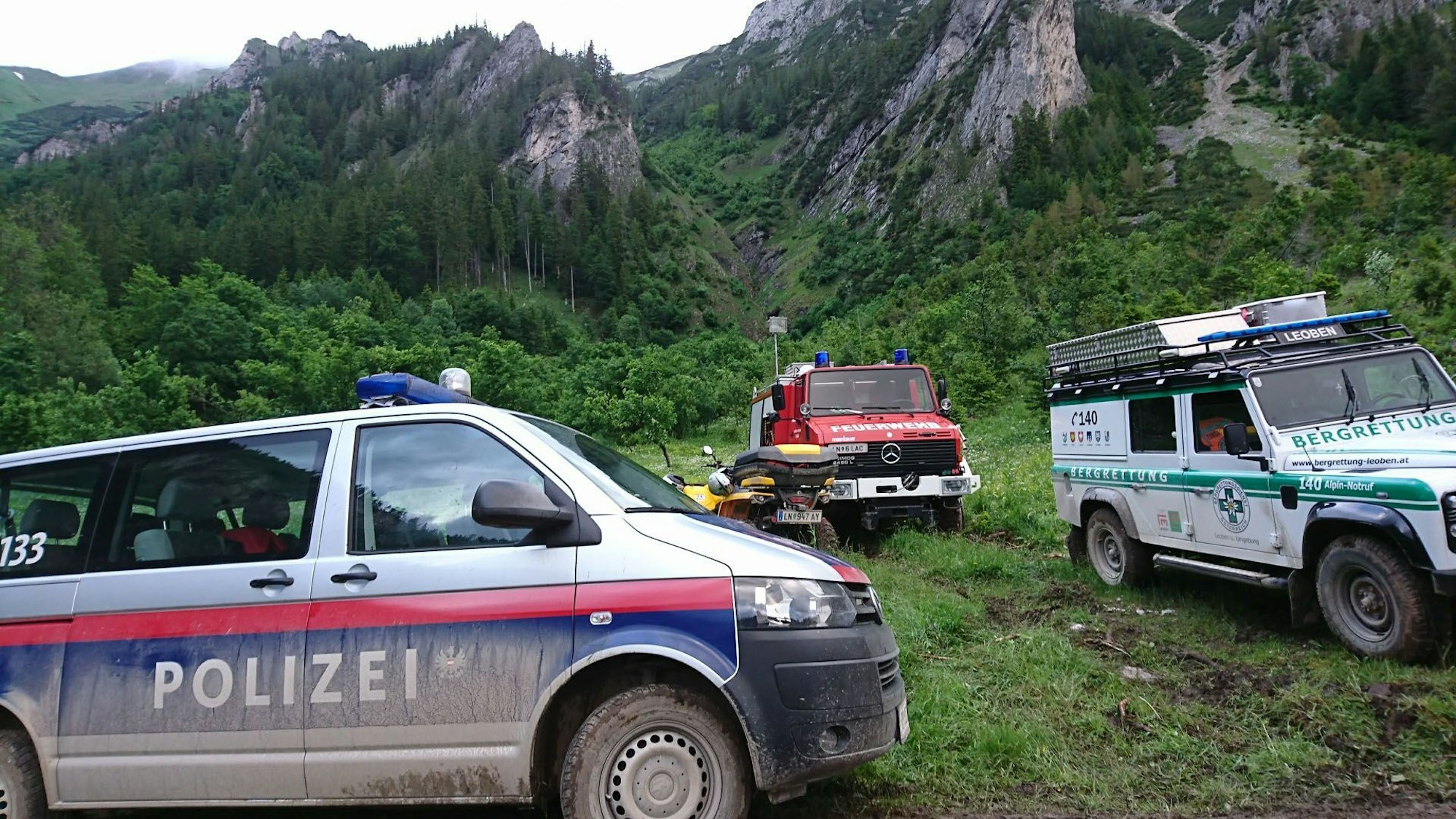Einsatzfahrzeuge von Polizei, Feuerwehr und Bergrettung bei einem Rettungseinsatz