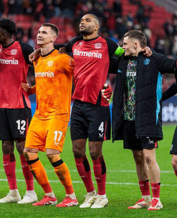 Spieler von Bayer Leverkusen feiern nach einem Champions-League-Sieg vor der Fankurve.