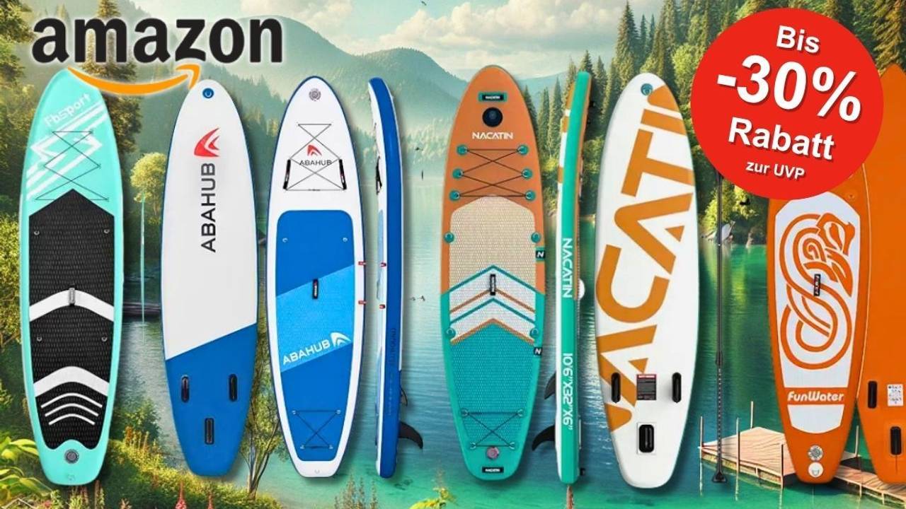Eine farbenfrohe Auswahl an aufblasbaren Stand Up Paddling Boards aufgereiht vor einem idyllischen Seehintergrund mit Bergen und Wald.