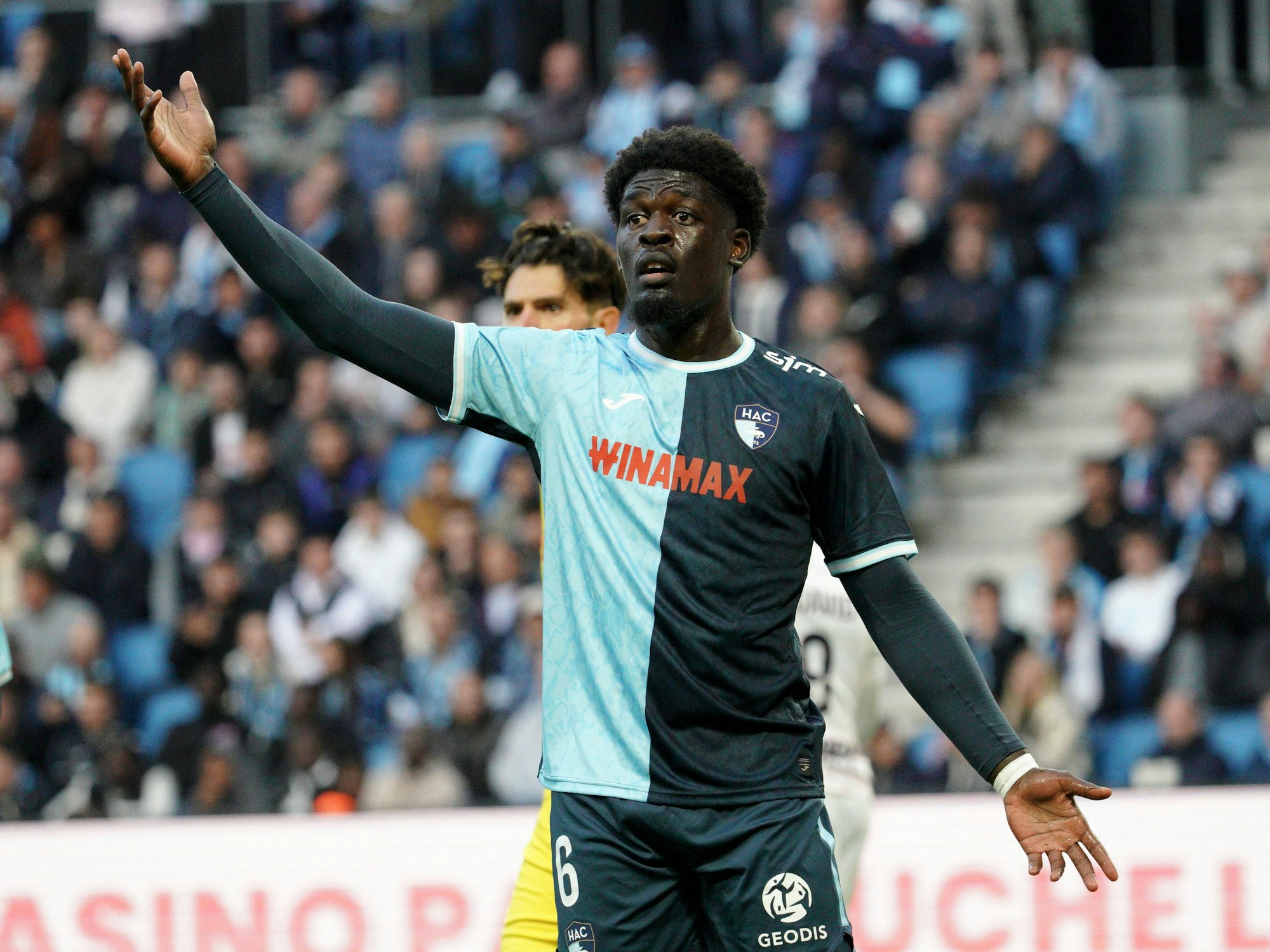 Etienne Youté Kinkoué gestikuliert auf dem Platz.