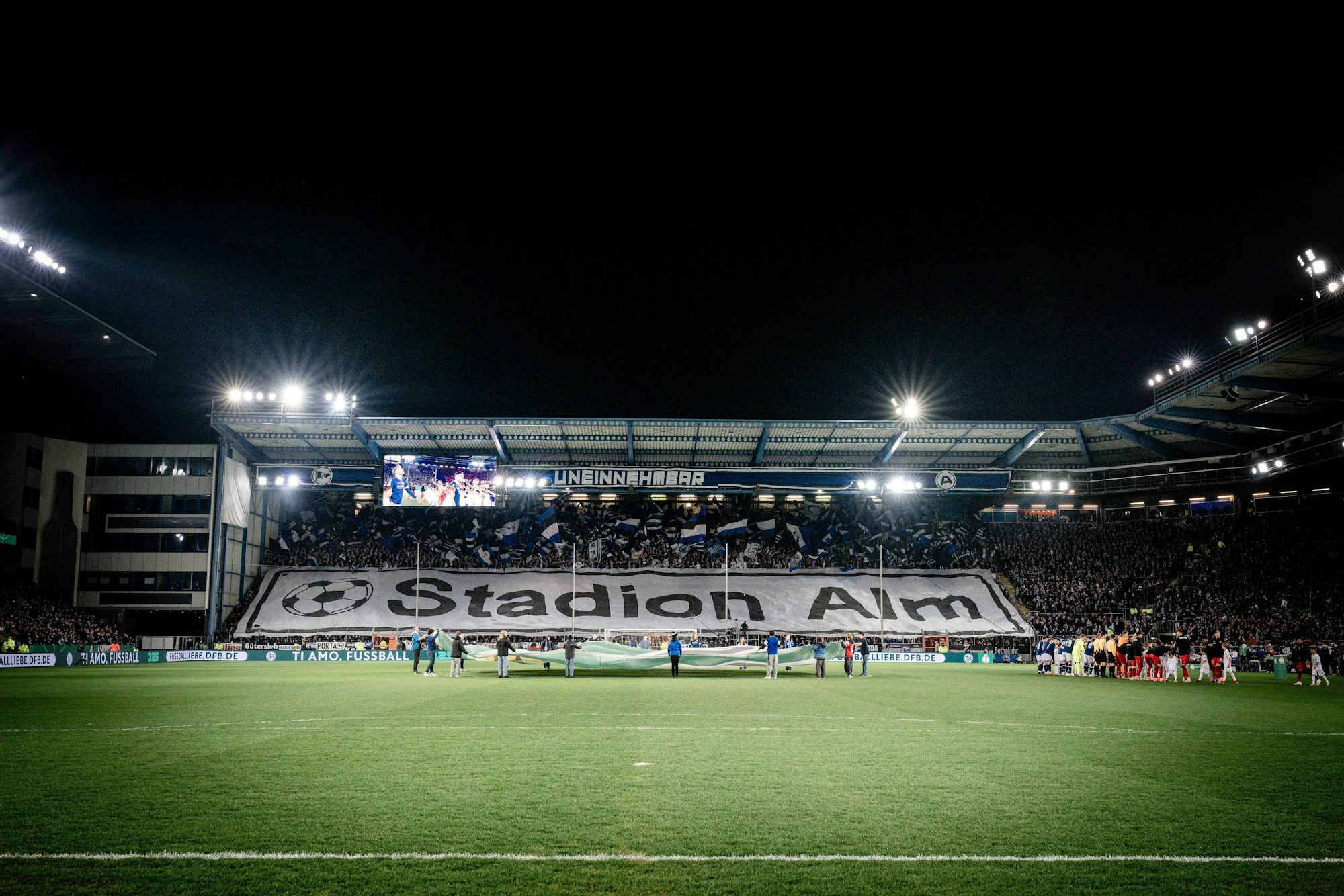 Bielefeld-Fans mit einer Choreo unter Flutlicht.