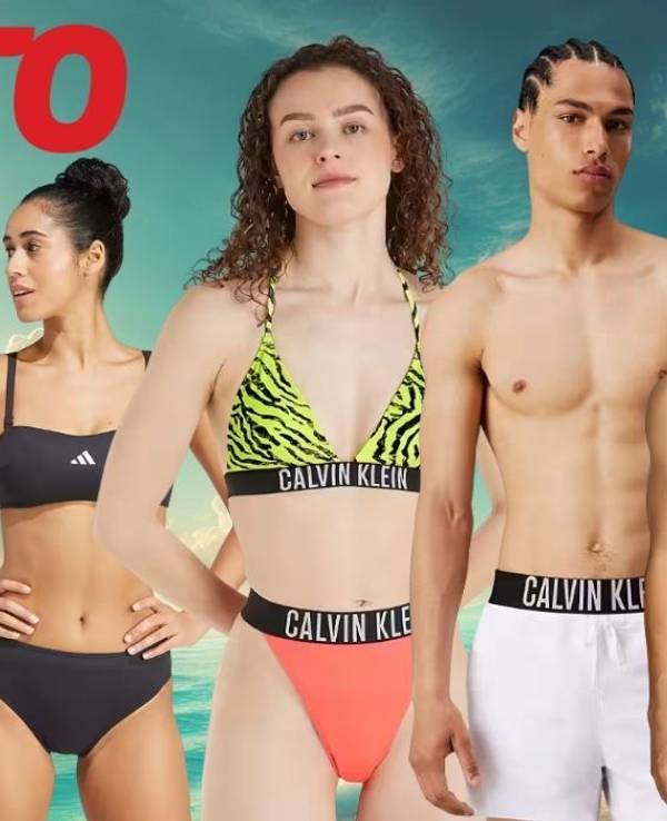 Eine sommerliche Strandkulisse mit vier jungen Erwachsenen in trendiger Bademode von Marken wie adidas und Calvin Klein.