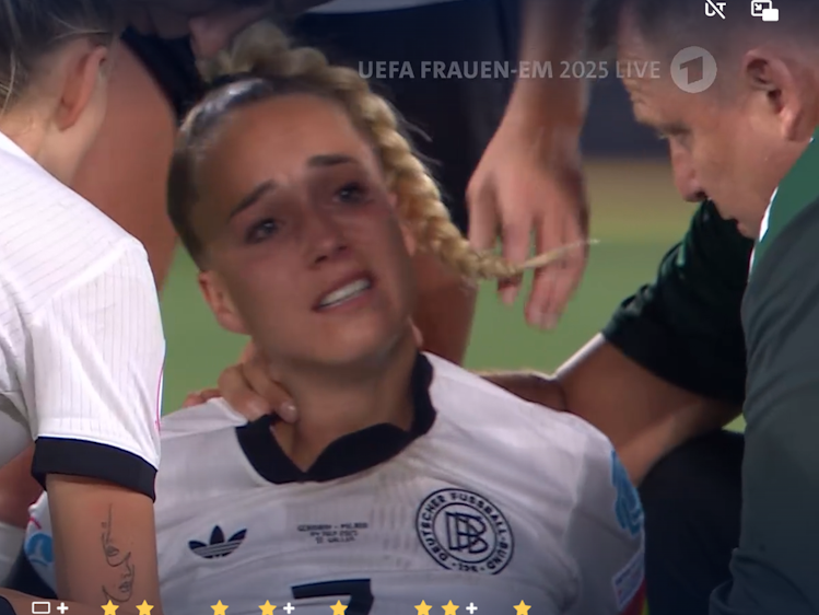 Giulia Gwinn sitzt auf dem Spielfeld und weint.