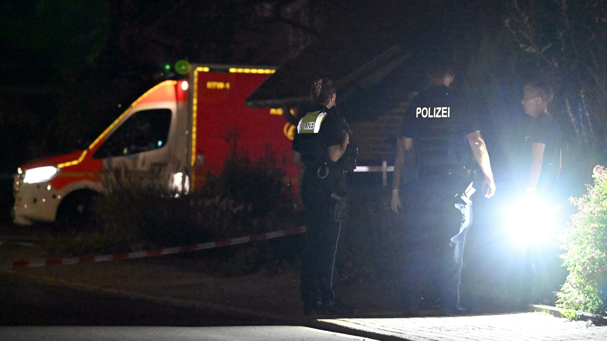 Polizeibeamte befragen Menschen auf einer Straße (Symbolfoto).