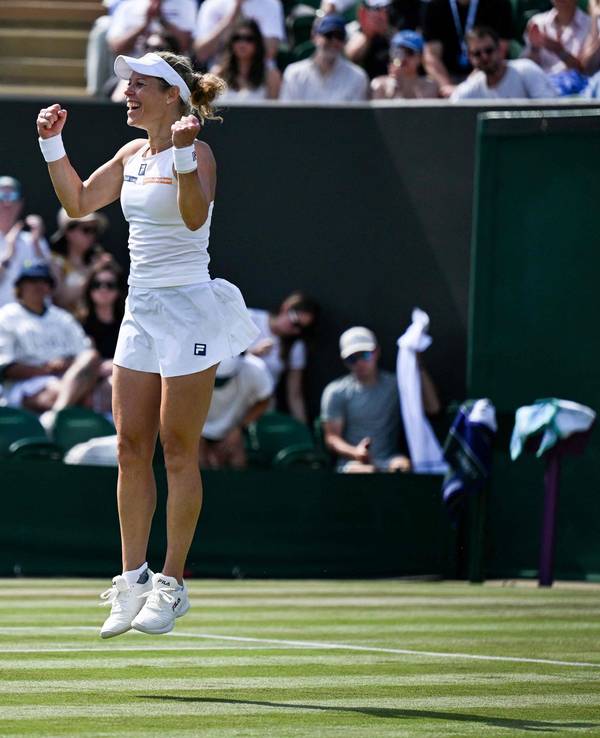 Laura Siegemund spring vor Freude auf dem Rasen von Wimbledon in die Höhe.