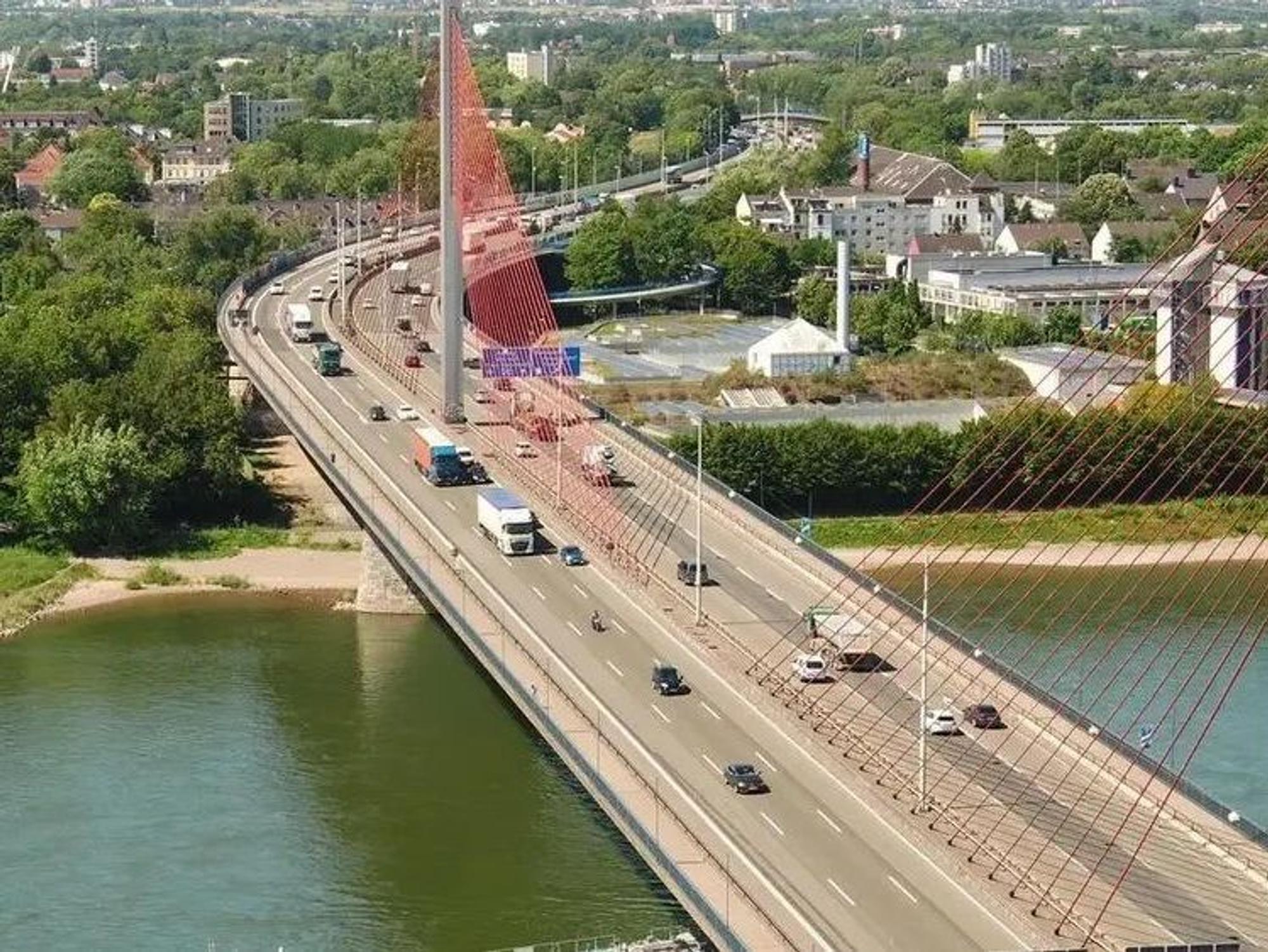 Fahrzeuge fahren über eine Brücke, die über einen Fluss führt.