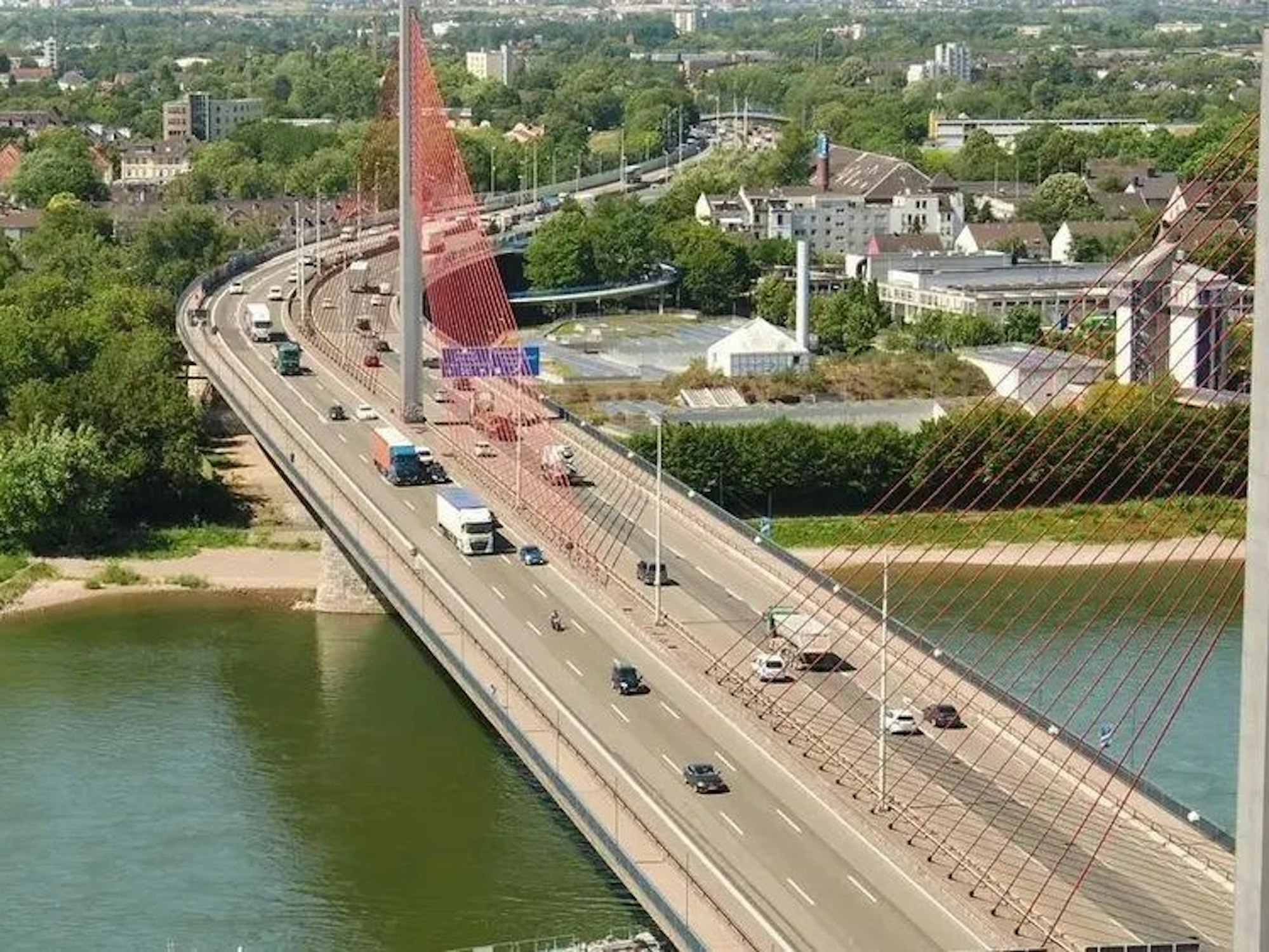 Fahrzeuge fahren über eine Rheinbrücke.