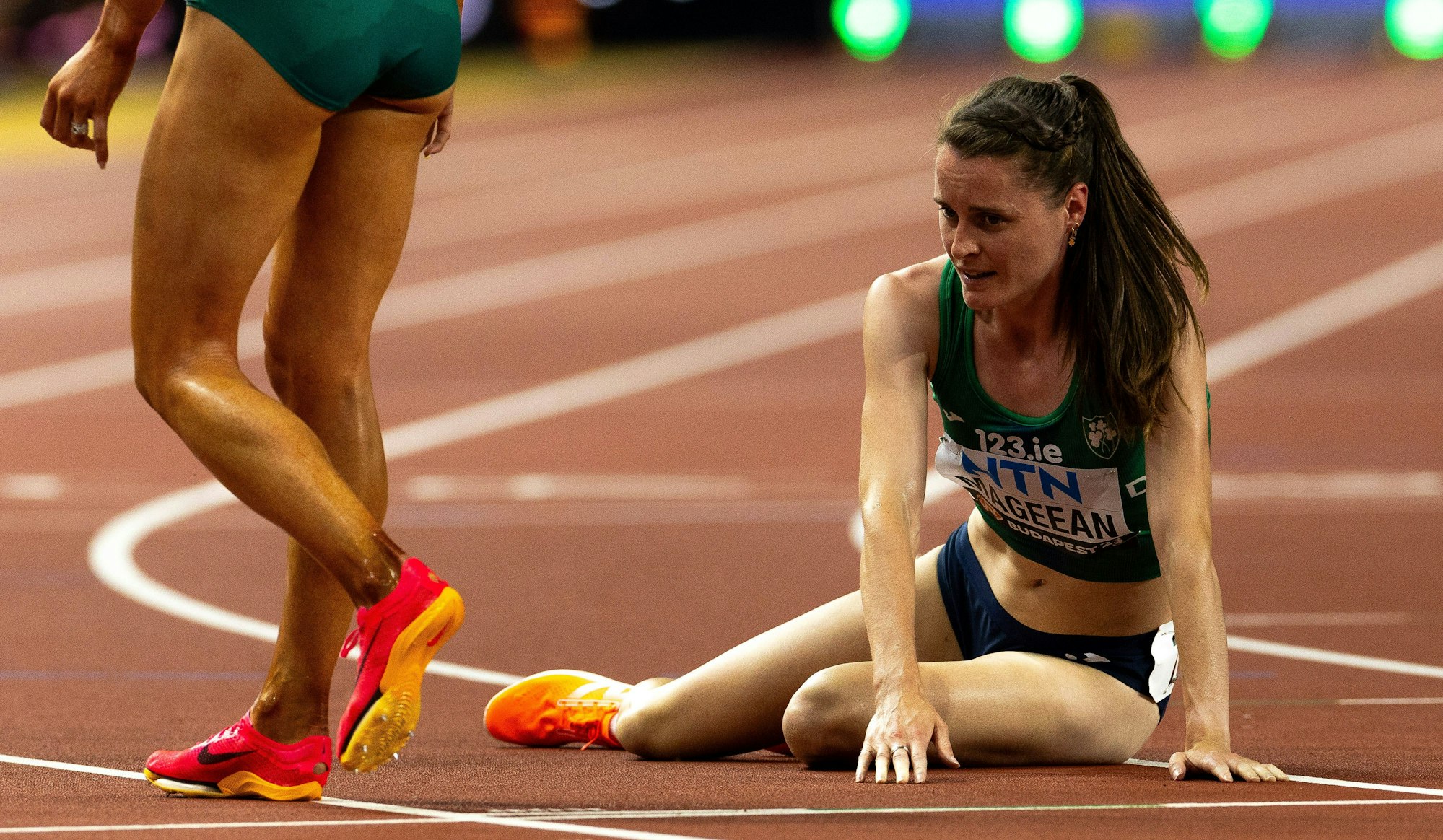 Ciara Mageean sitzt nach den 1500 Metern bei der Leichtathletik-WM 2023 in Budapest erschöpft auf der Laufbahn.