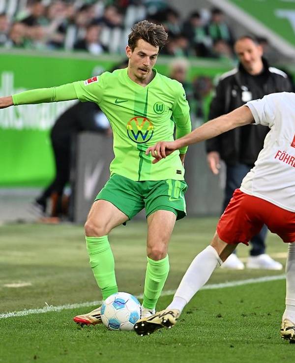 Wolfsburgs Jakub Kamiński (l) spielt gegen Heidenheims Jonas Föhrenbach.