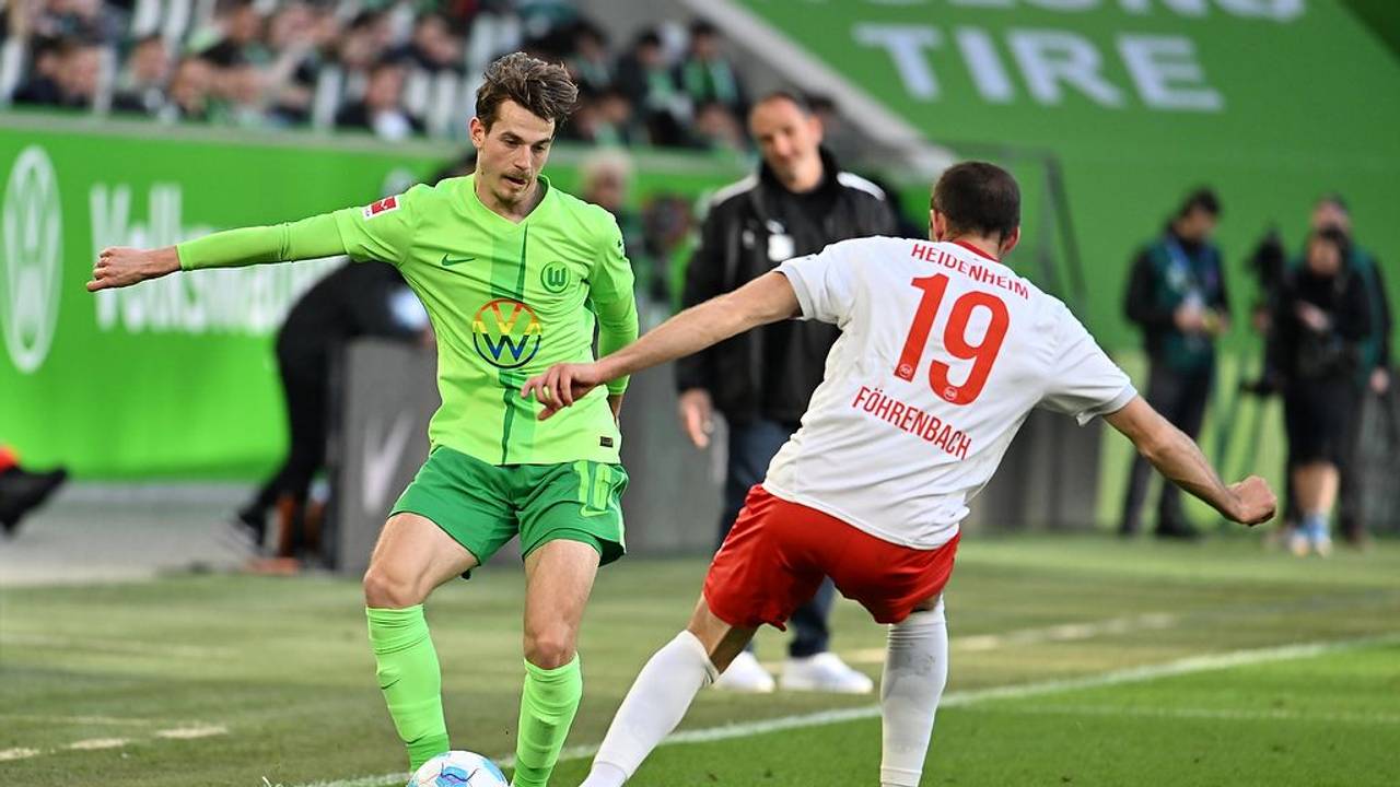 Wolfsburgs Jakub Kamiński (l) spielt gegen Heidenheims Jonas Föhrenbach.