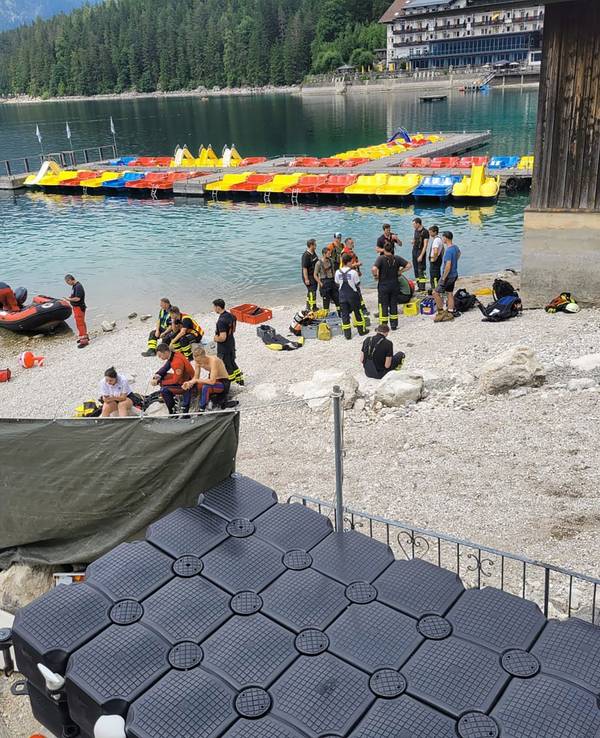 Dieses vom Bayerischen Roten Kreuz zur Verfügung gestellte Foto zeigt Rettungskräfte am Ufer des Eibsees in Bayern. Ein 33 Jahre alter Mann und sein kleiner Sohn sind bei einem Badeunfall auf dem oberbayerischen Eibsee untergegangen.
