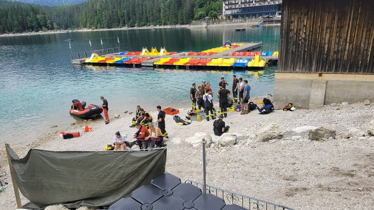 Dieses vom Bayerischen Roten Kreuz zur Verfügung gestellte Foto zeigt Rettungskräfte am Ufer des Eibsees in Bayern. Ein 33 Jahre alter Mann und sein kleiner Sohn sind bei einem Badeunfall auf dem oberbayerischen Eibsee untergegangen.