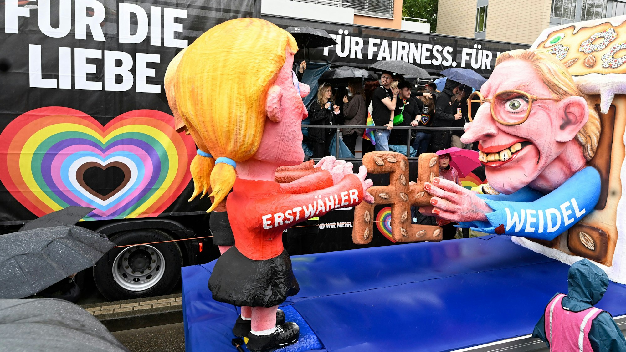 Ein Wagen des Rosenmontagszug wartet beim diesjährigen Christopher-Street-Day (CSD) Umzug auf seinen Einsatz, mit einer Figur von Alice Weidel und einer von einer Erstwählerin. Die Demonstranten treten für bessere Rechte der LGBTQ-Community ein.