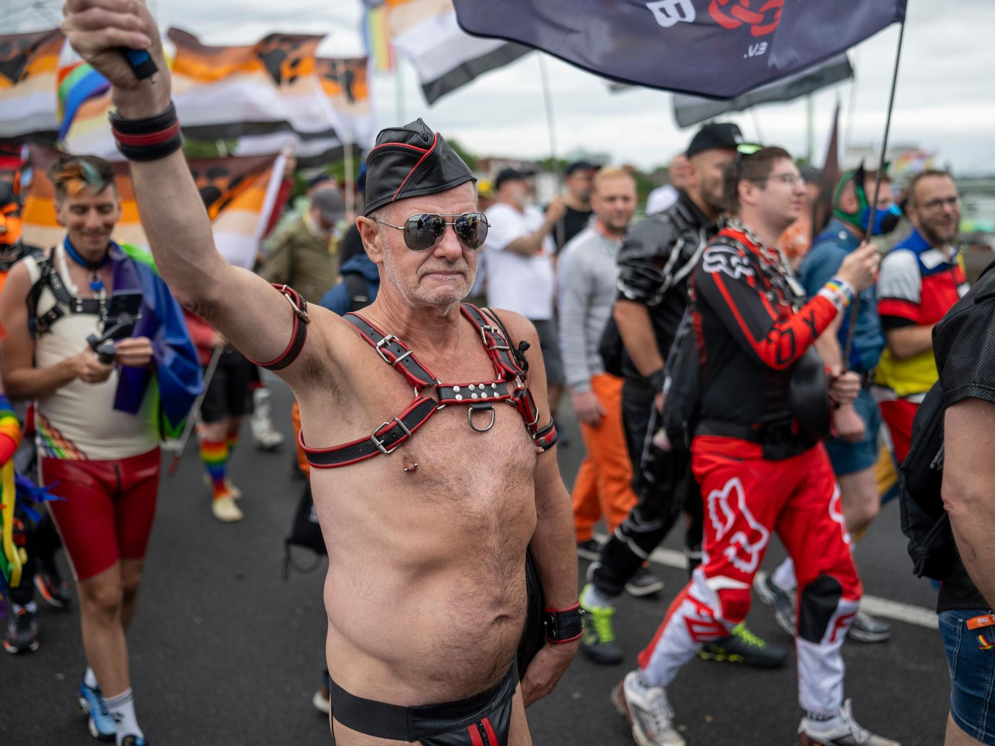 Queere Menschen gehen in freizügigen Kostümen bei der Parade zum Christopher Street Day mit.