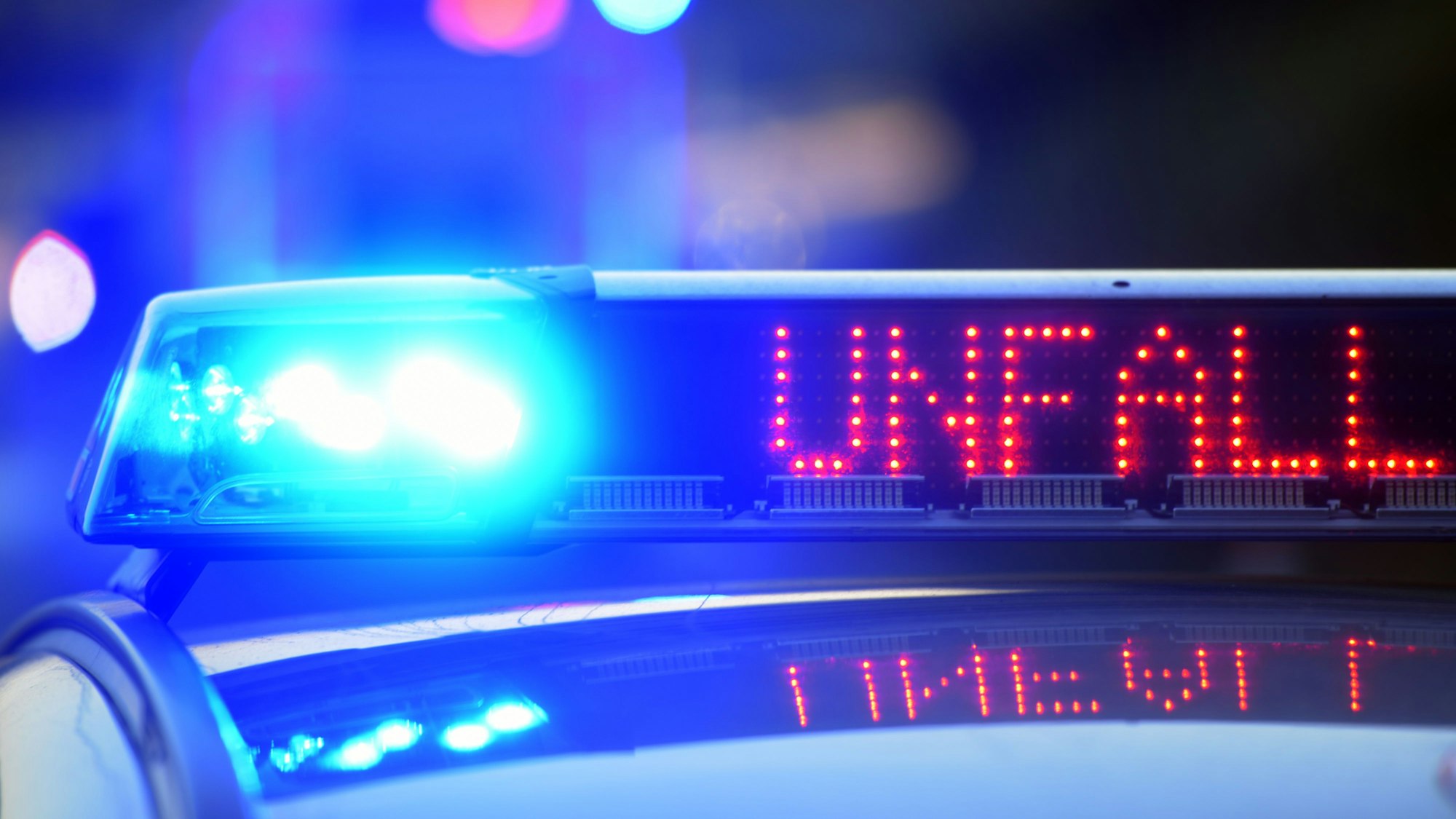 Auf einem Polizeifahrzeug warnt eine Leuchtschrift vor einer Unfallstelle.