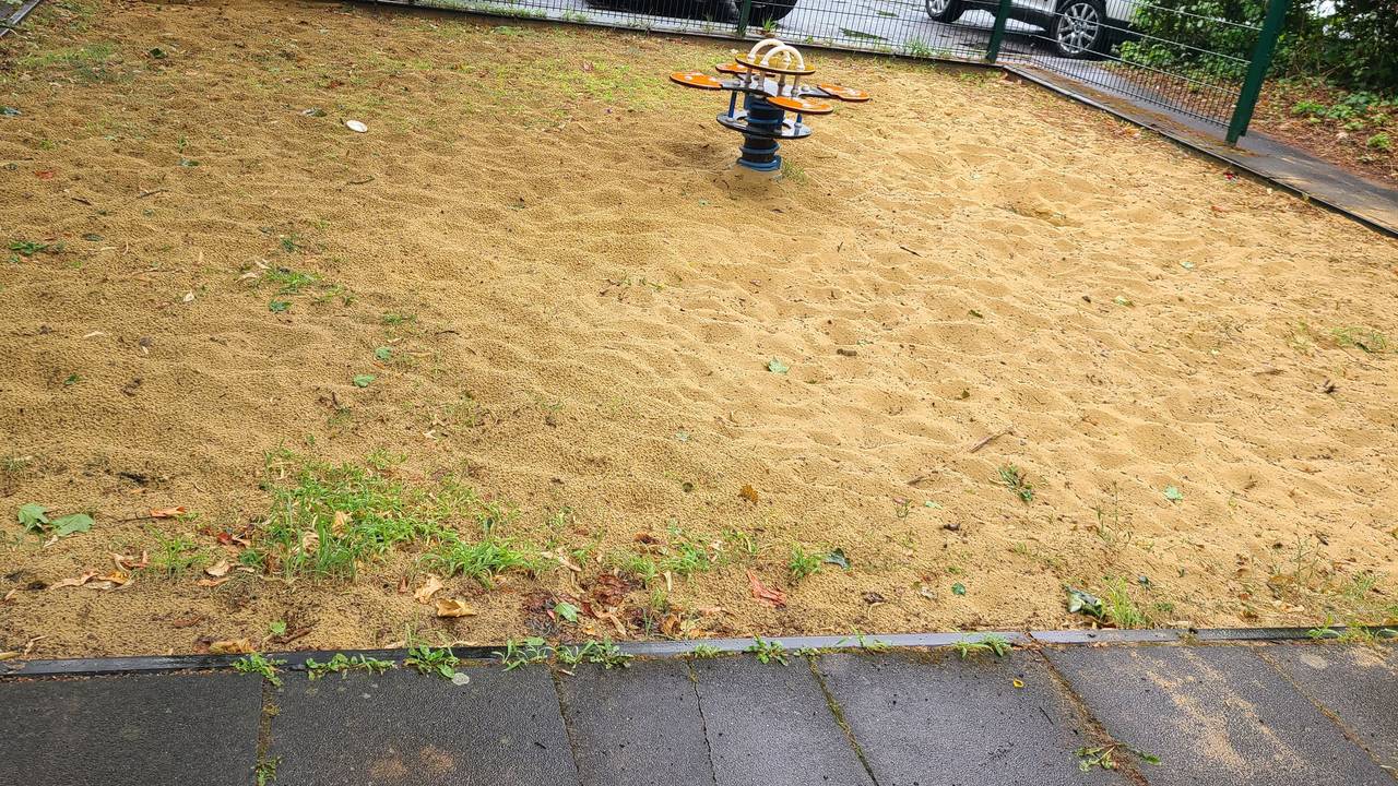 Eine Sandfläche mit einem Spielgerät.