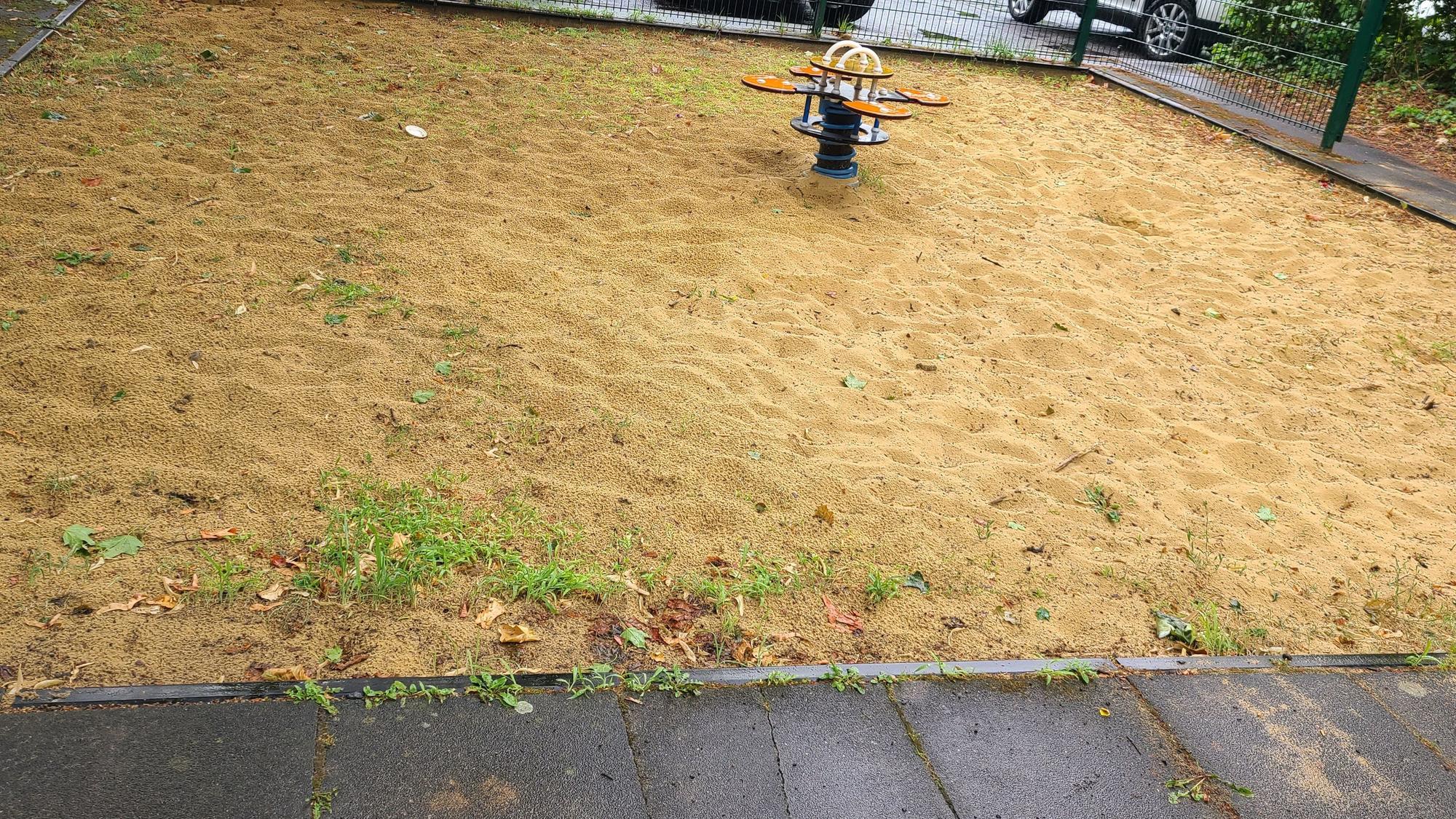 Eine Sandfläche mit einem Spielgerät.