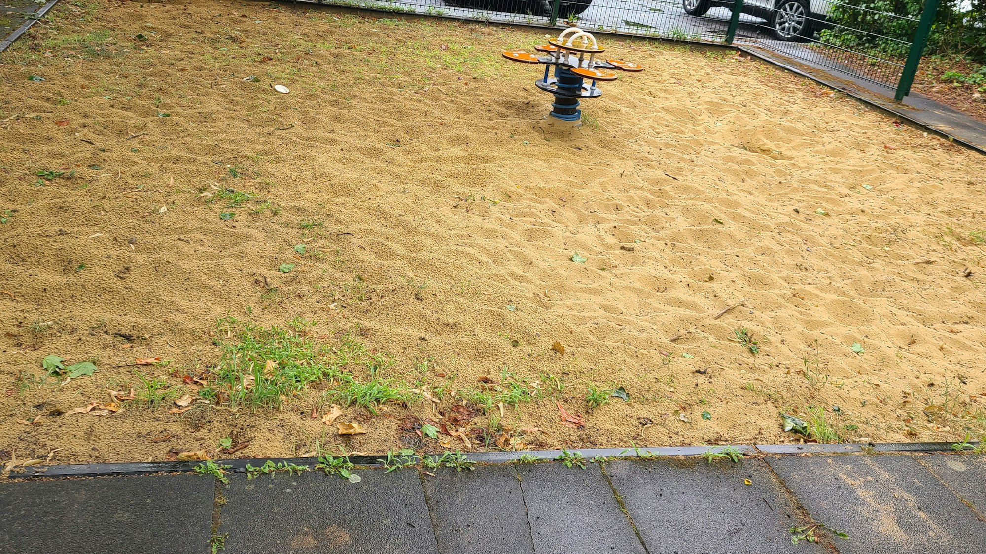 Eine Sandfläche mit einem Spielgerät.