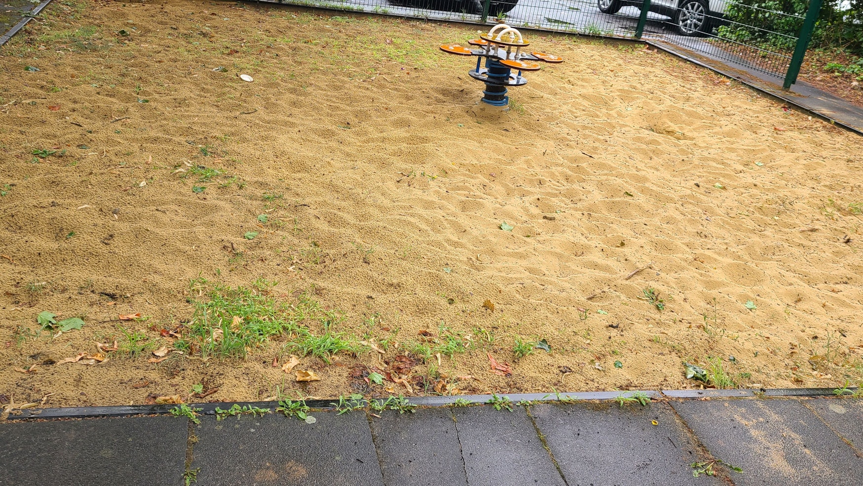 Eine Sandfläche mit einem Spielgerät.