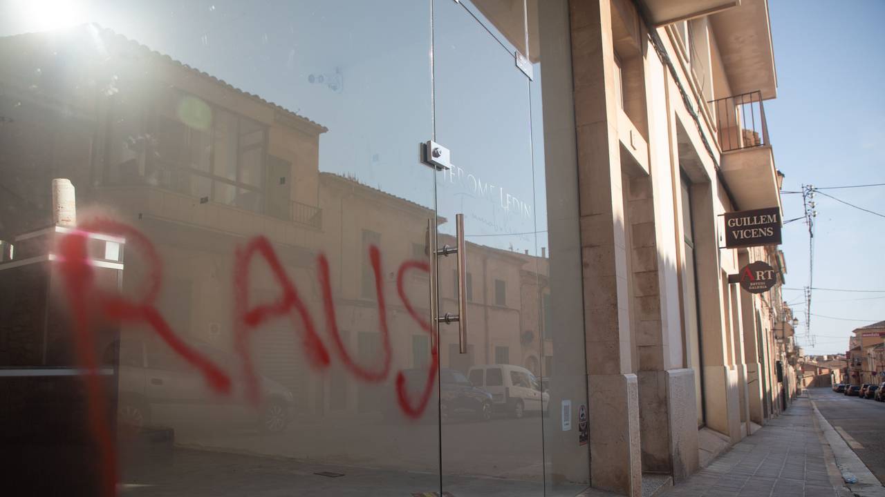 Ein Graffiti mit der Aufschrift „Raus“ ist am Fenster eines Immobilienbüros in Santanyi auf Mallorca zu sehen. Unbekannte haben deutschenfeindliche Sprüche auf Autos und Geschäfte in dem kleinen Ort Santanyi auf Mallorca gesprüht.