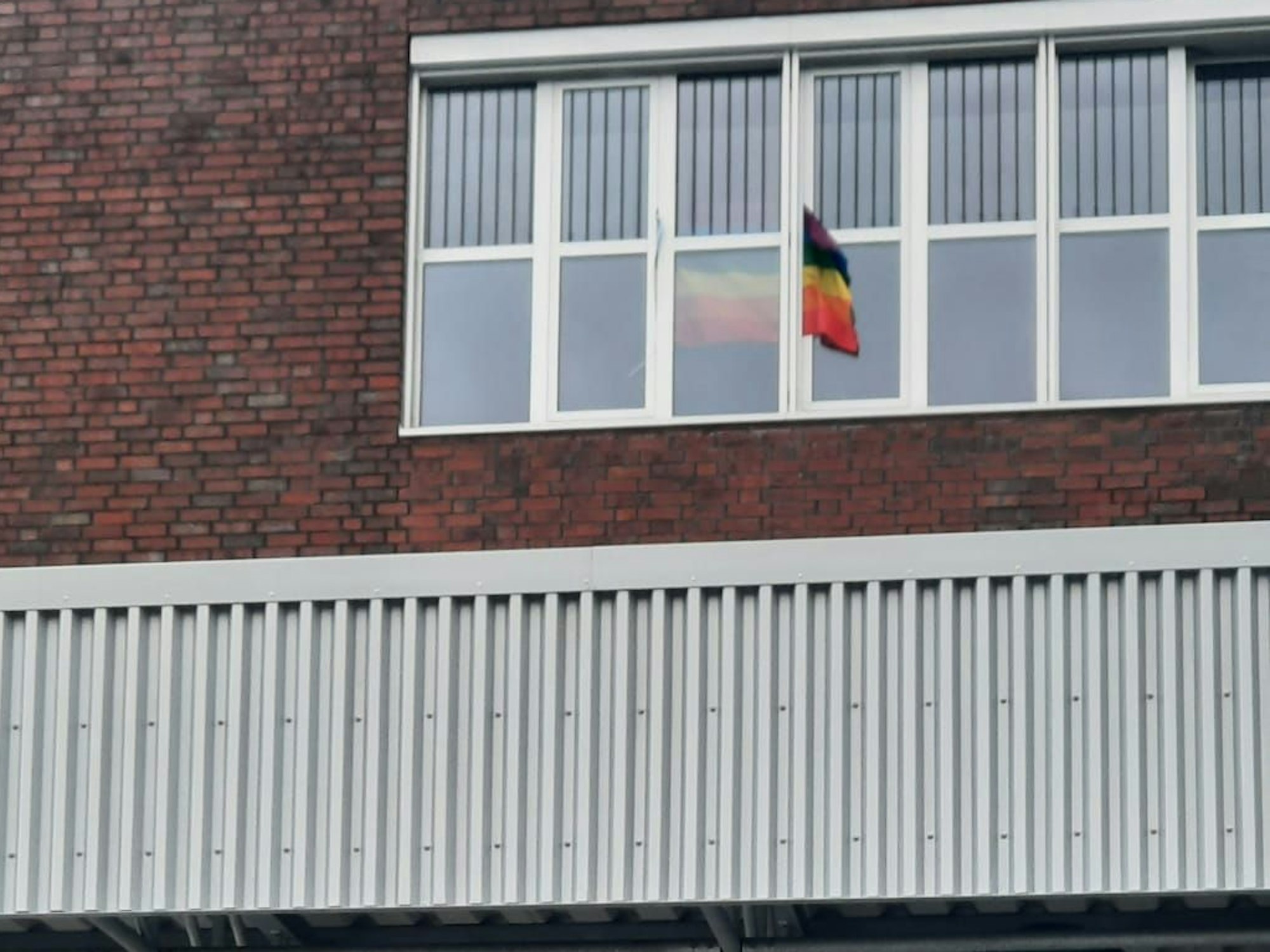 Zeichen des Protests: Regenbogenfahne am Montagmorgen im Fenster des Bildungscampus Köln-Kalk