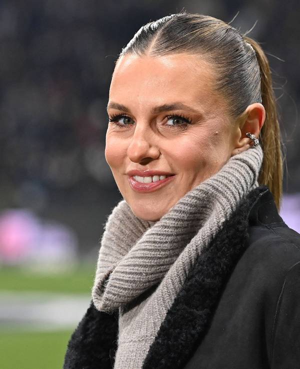 Laura Wontorra lächelt im Stadion in die Kamera.