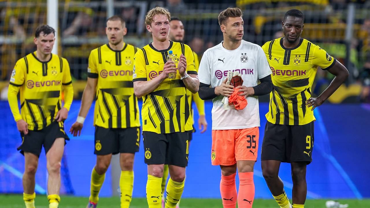 Marcel Lotka geht zwischen Julian Brandt und Serhou Guirassy über den Rasen im Signal-Iduna-Park.