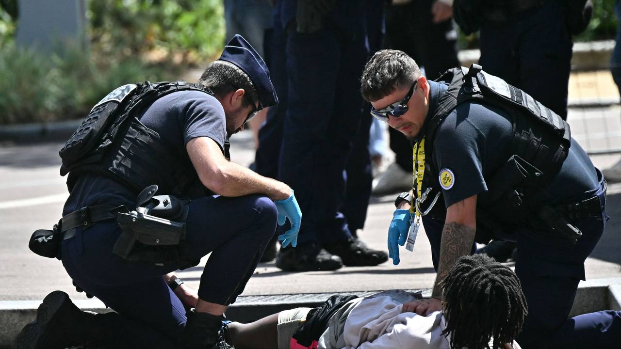 Polizisten bei der Festnahme des Messer-Angreifers am Rande der Strecke der Tour de France.