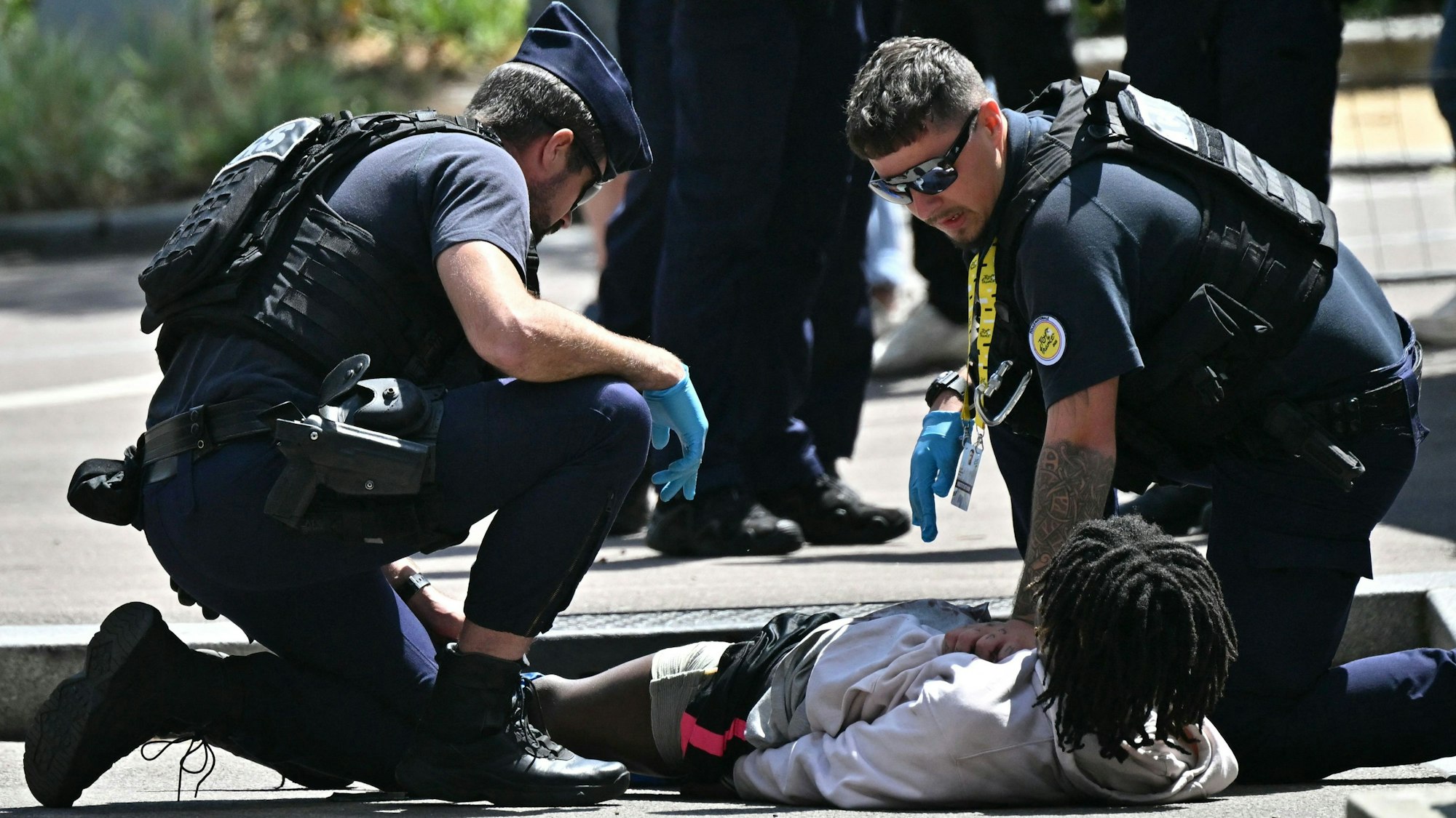 Polizisten überwältigen einen Mann am Rande der vierten Etappe der Tour de France.
