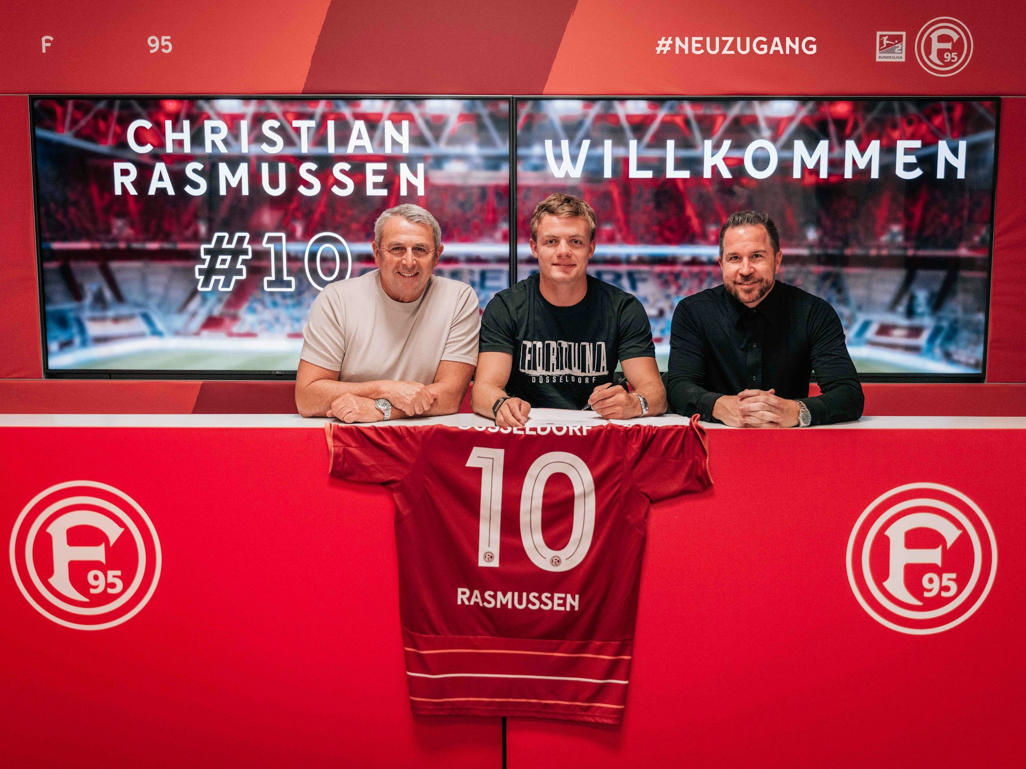 Christian Rasmussen sitzt zwischen Klaus Allofs und