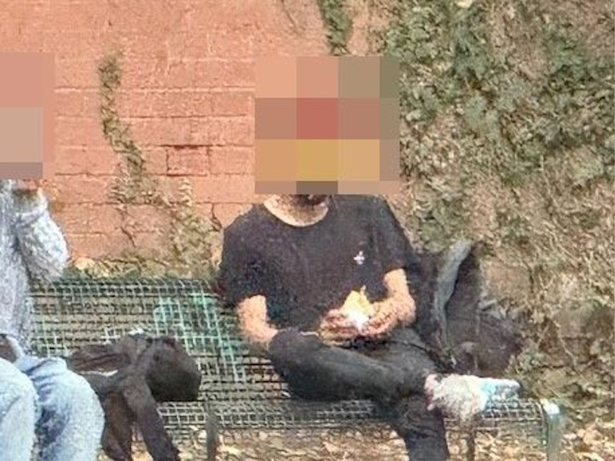 Zwei Männer sitzen auf einer Bank und rauchen Crack.