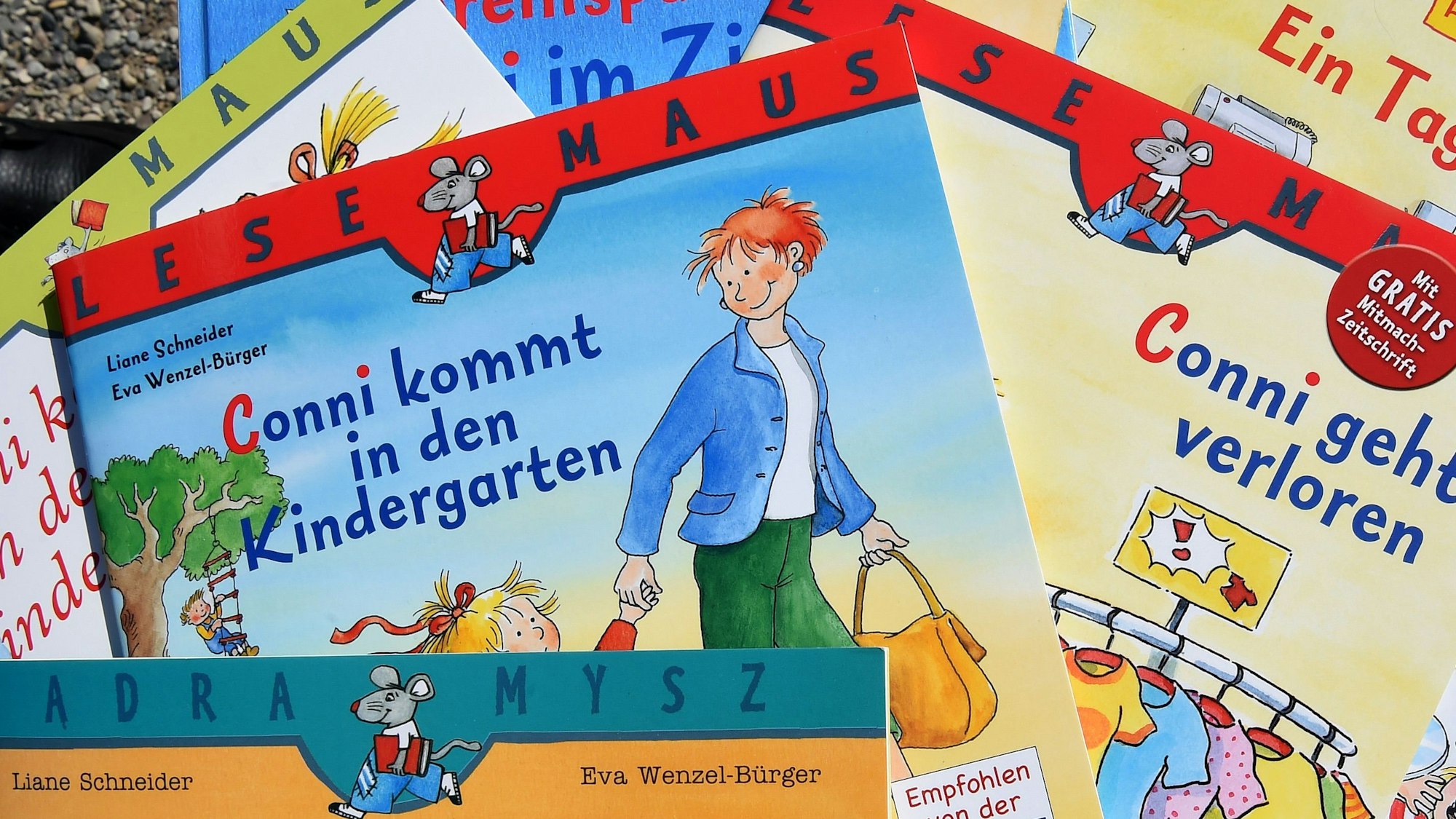 Mehrere Conni-Bücher liegen auf einem Tisch. Die Bücher sind bunt und zeigen die Figur Conni.