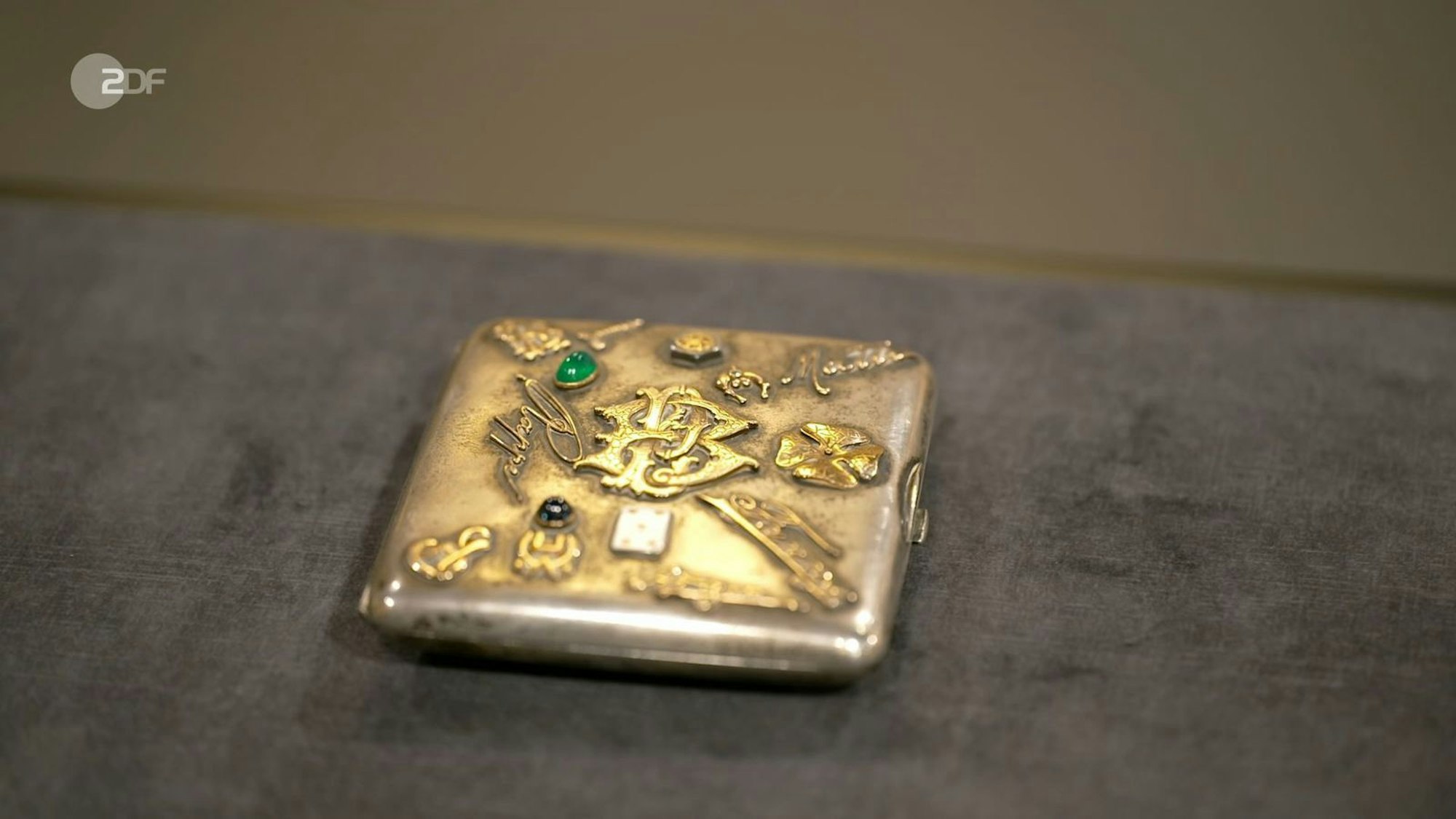 Die Expertin Dr. Heide Rezepa-Zabel befasste sich intensiv mit dem Zigaretten-Etui aus dem jahr 1908t: Die Applikationen waren aus Emaille, Gold und Edelsteinen. Den Wunschpreis von 80 Euro konnte Rezepa-Zabel deswegen toppen: Allein der Goldwert lag bei 1.650 Euro. Insgesamt empfahl sie 2.000 bis 2.500 Euro. (Bild: ZDF)