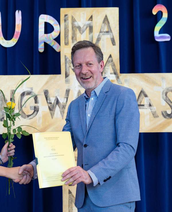 Lina Heider erhält mit gerade einmal elf Jahren ihr Abschlusszeugnis von Christoph Oldeweme, Schulleiter des Erzbischöflichen Mädchen-Gymnasium Sankt-Adelheid.