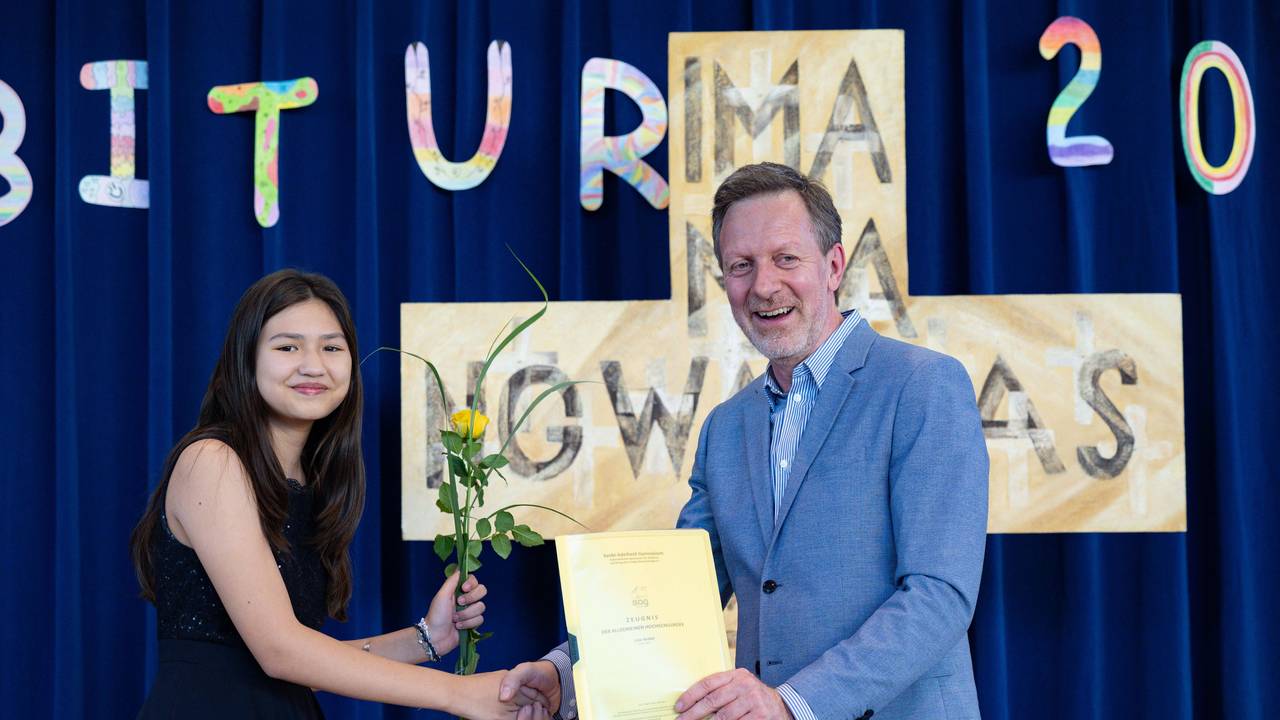 Lina Heider erhält mit gerade einmal elf Jahren ihr Abschlusszeugnis von Christoph Oldeweme, Schulleiter des Erzbischöflichen Mädchen-Gymnasium Sankt-Adelheid.