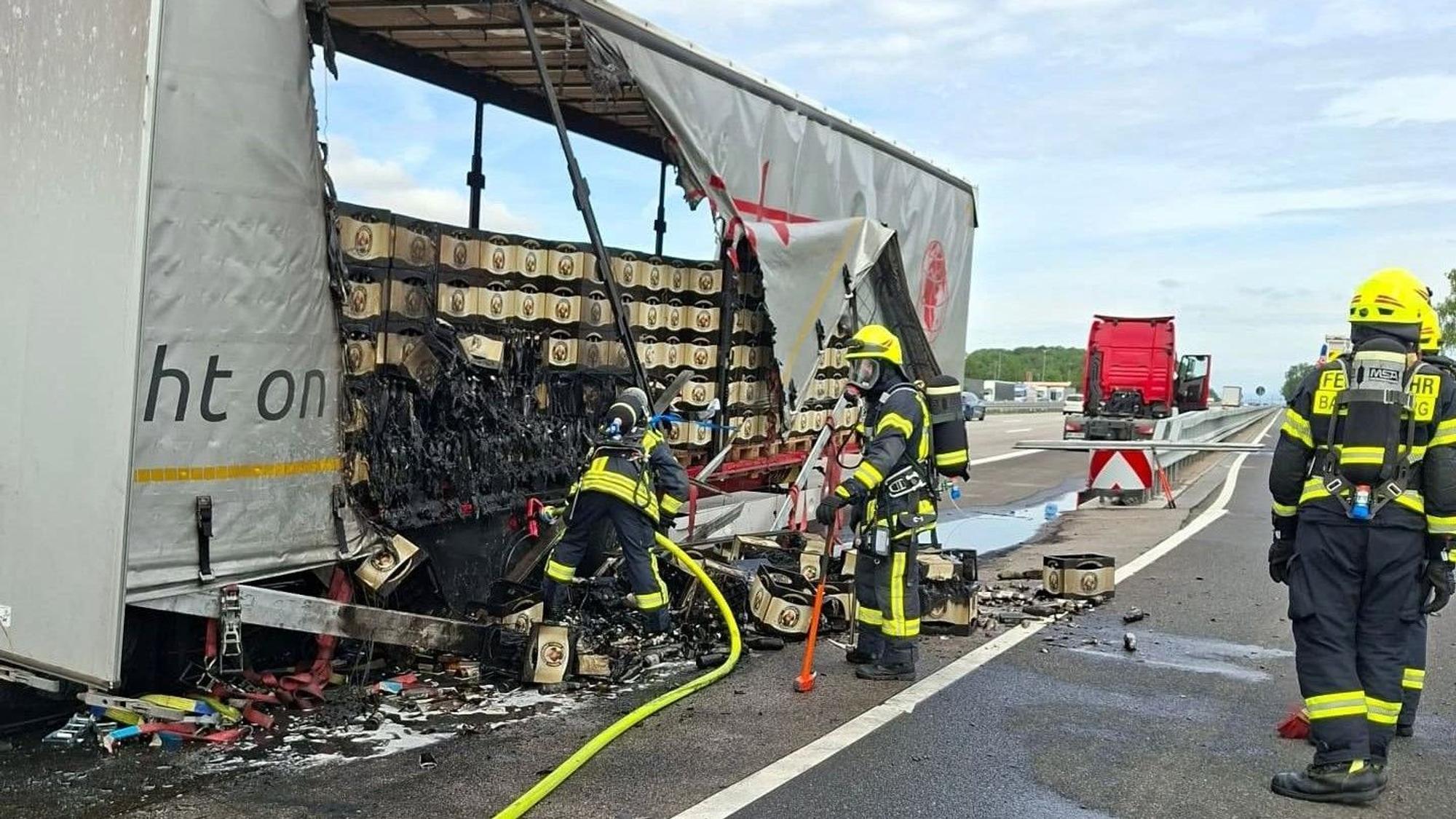 Feuerwehrleute bei den Löscharbeiten nach dem Brand eines mit Bier beladenen LKW auf der A3.