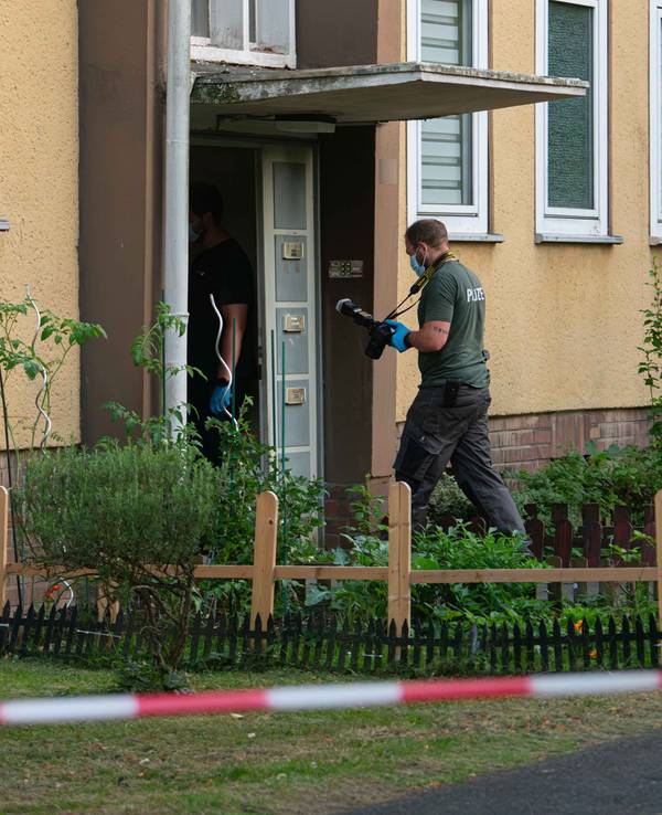 Ermittler der Polizei betreten ein Wohnhaus in Dormagen.