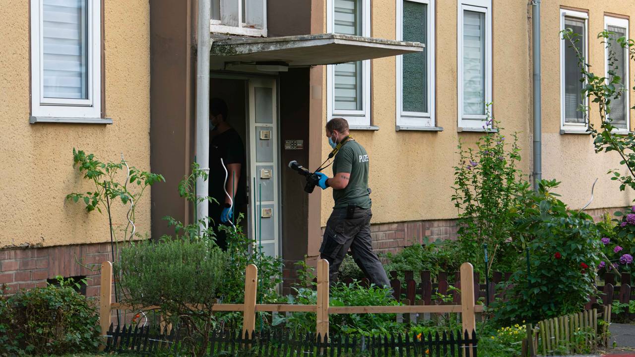 Ermittler der Polizei betreten ein Wohnhaus in Dormagen.