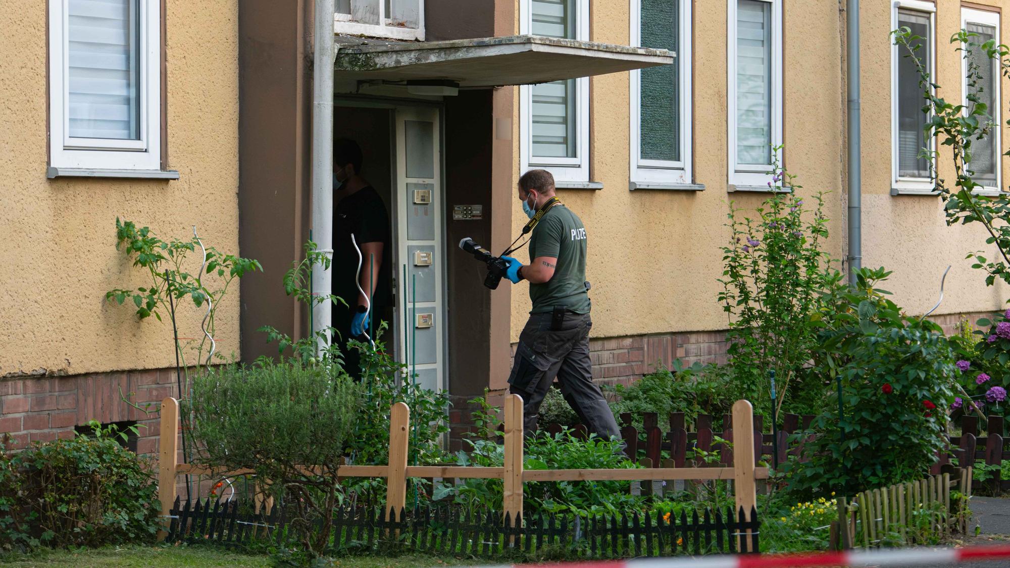 Ermittler der Polizei betreten ein Wohnhaus in Dormagen.