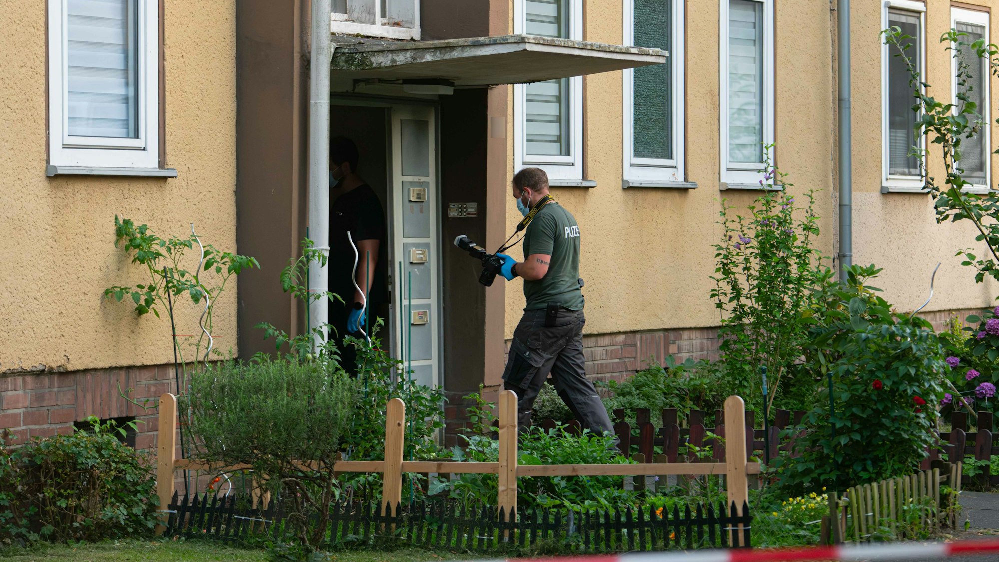 Ermittler der Polizei betreten ein Wohnhaus in Dormagen.
