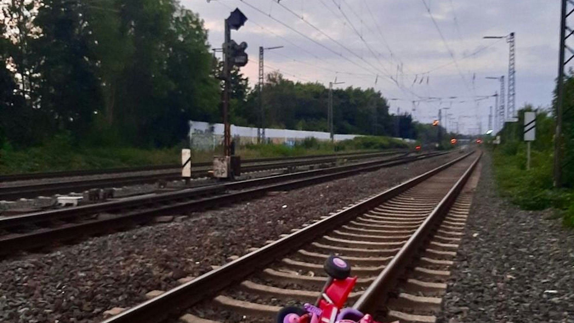 Ein Kinderdreirad liegt in den Bahngleisen.